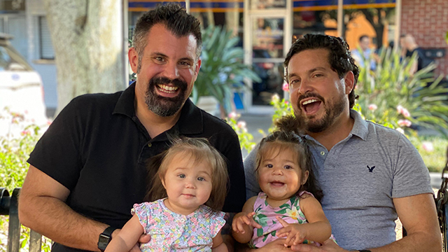 Closeup of two dads with their daughters